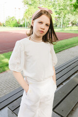 Girl spending time alone at city park in beautiful warm sunny day.