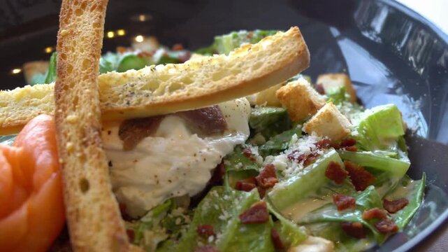 Close up of caesar salad with croutons, bacon, and parmesan cheese in a bowl