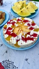 Summer Picnic Table with Pancakes, Fruit Cake, Yellow Watermelon, and Drinks. Outdoor Lunch in a Garden