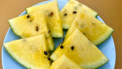 Plate of Sliced Yellow Watermelon on a Solid Background. Fresh Summer Dessert