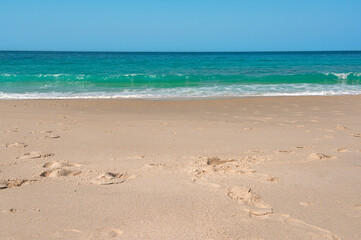 Turquoise ocean waves crashing on sandy beach paradise