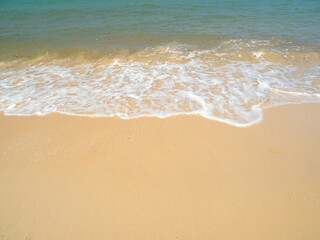 Serene tropical beach with crystal clear turquoise water, gentle waves, and a bright blue sky with...