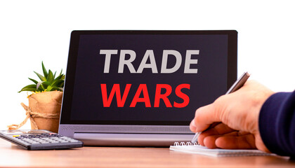 Trade wars symbol. Concept word Trade wars on beautiful black tablet. Businessman's hand with pen....