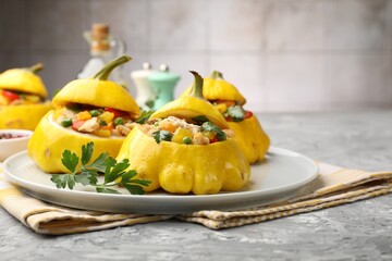 Tasty stuffed pattypan squashes on grey textured table, closeup