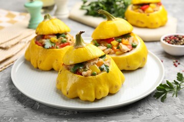Tasty stuffed pattypan squashes on grey textured table, closeup