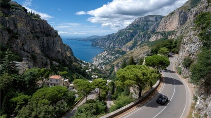 Fototapeta premium Black SUV travels along a picturesque cliffside route overlooking sparkling blue waters and lush greenery under a clear sky