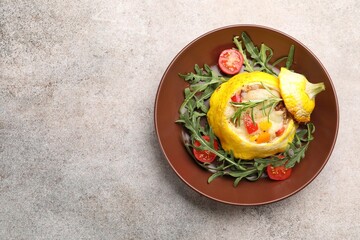 Tasty stuffed pattypan squash with tomatoes and arugula on grey table, top view. Space for text