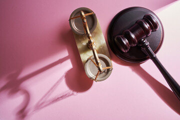 libra scale and gavel against pink background
