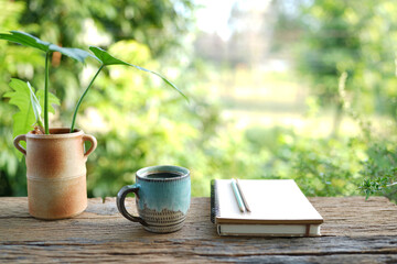 vintage coffee and notebook and potted plant on rustic wooden table