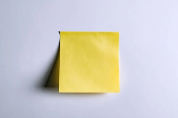 A single, bright yellow sticky note affixed to a plain white surface