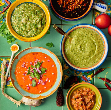 Mexican style salsa's and sauces on green tile background