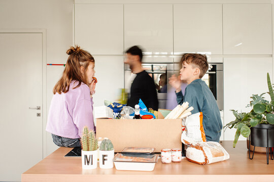 Blurry courier behind family unpacking