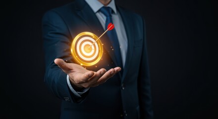 Businessman holding a golden target with an arrow in the bullseye