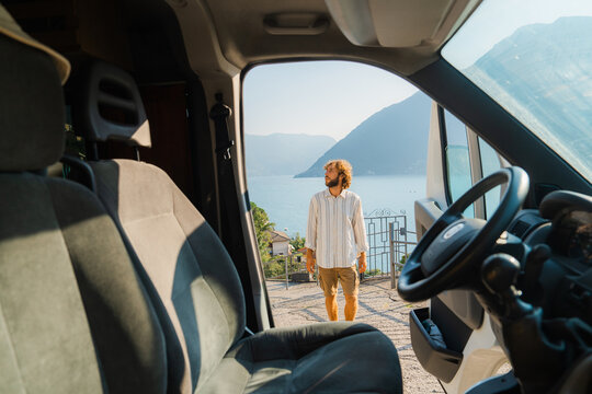 Man stepped out of the car during road trip with camper van 
