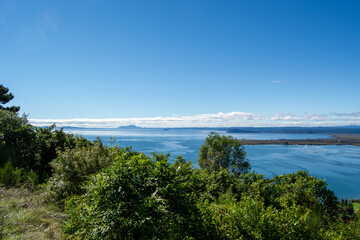 Scenic Lake View with Lush Greenery and Blue Sky