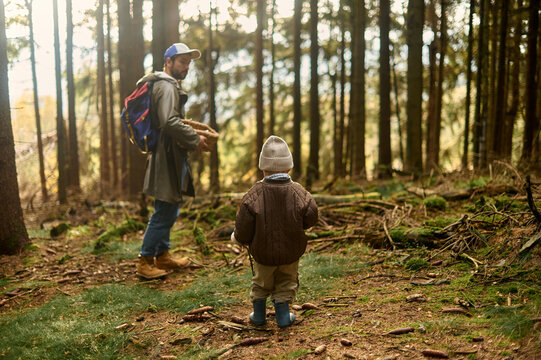 Father and son walking in autumn forest