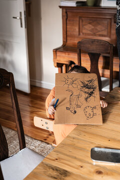 Child Hiding Behind a Drawing