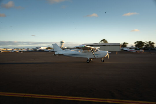 Small Aircraft Taxiing on Runway at Sunset