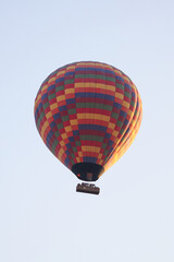 Multicolored Hot Air Balloon with Checkered Pattern Floating in Clear Morning Sky