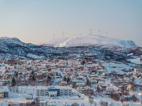 Winter townscape of Sortland with wind turbines on snowy hills