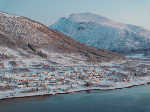 Snow-Covered Village Below Mountain in Winter