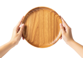 Photo of hands holding an empty round wooden plate isolated on transparent background for food presentation