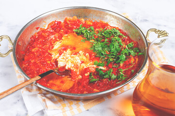 traditional Turkish dish, scrambled eggs with tomatoes, Menemen, with herbs, in a frying pan, close-up, no people,