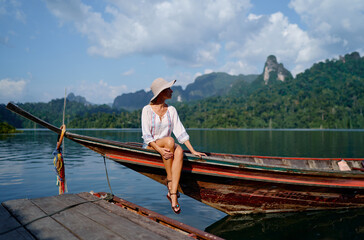 Woman Relaxing on a Wooden Boat in Scenic Tropical Lake