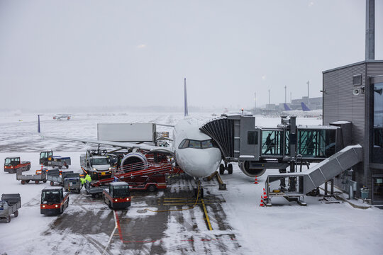 Airplane at snowy airport gate during winter operations