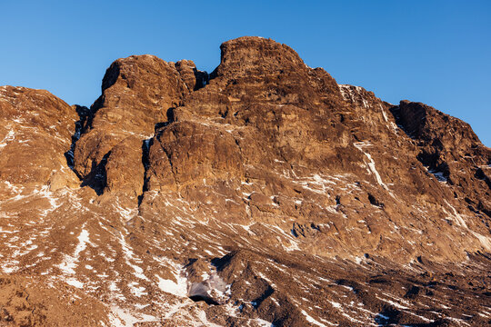 Rocky mountain peak with patches of snow