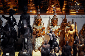 Golden Buddhist Statues with Ornamental Details Displayed in a Traditional Thai Setting