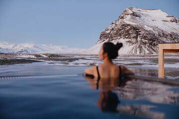 Woman relaxing in hot spring with snowy mountain view