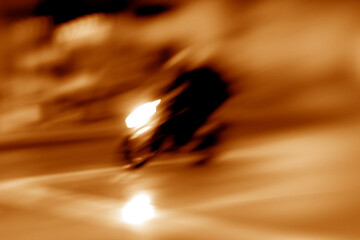 Fast motorcycle moving on a blurred background with light trails