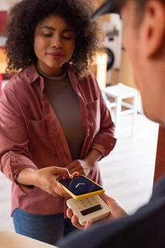 Happy client making mobile payment to a courier