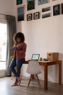 Woman reading advertisement brochure and preparing phone call