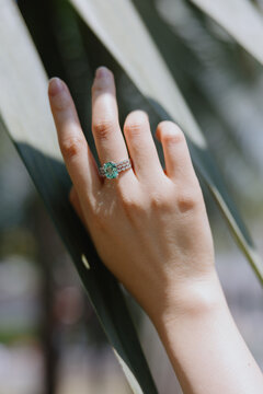 Hand Wearing Green Gemstone Ring in Sunlight