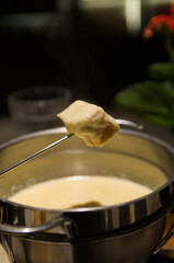 Traditional cheese fondue with bread and a glass of wine.