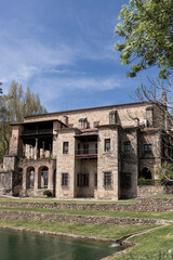 Obraz premium Medieval spanish castle overlooking tranquil pond on sunny day