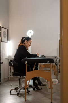 Artist Working on a Tattoo Design in a Bright Studio