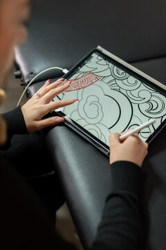 Tattoo artist creating a new design on digital tablet