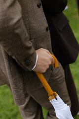 Gentleman hand holding white umbrella handle