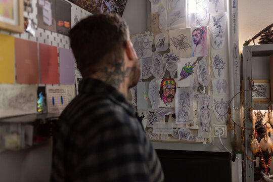 Man observing tattoo designs at studio