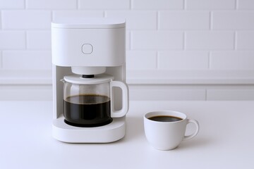 Modern White Coffee Maker with Glass Carafe and Matching Cup on White Countertop