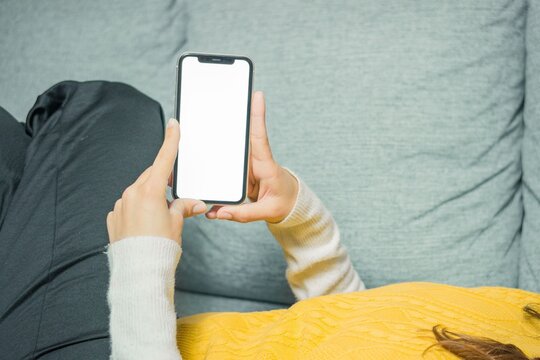 Woman using smartphone on a sofa