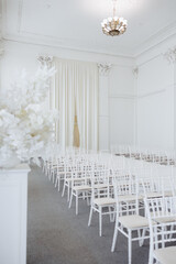Elegant white wedding ceremony hall with chairs