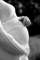 Close-up of expecting mother in ribbed dress