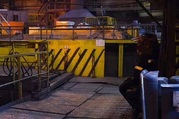 Blast furnace operator resting while sitting on chair near equipment