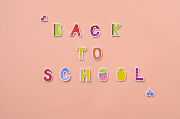 back to school inscription made of children's letters on a peach background