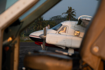 Twin-engine aircraft on tarmac seen through cockpit doorway