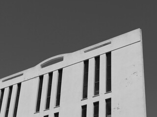 Upper part of a modern building photographed in black and white. The architecture features clean...